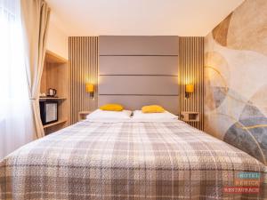 una camera da letto con un letto grande con cuscini gialli di Hotel Benica a Benešov