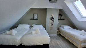 two beds in a room with a attic at la maison du bord de mer in Penvénan