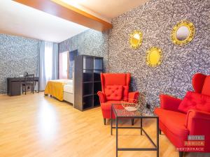 sala de estar con sillas rojas y cama en Hotel Benica, en Benešov