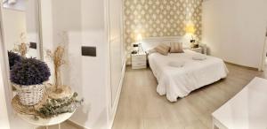 Un dormitorio blanco con una cama y flores. en Loft del Mar & Parking, en Rota