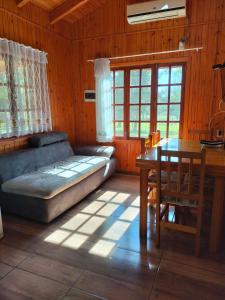 ein Wohnzimmer mit Sofa und Tisch in der Unterkunft Los Lapachos Lodge in Puerto Libertad