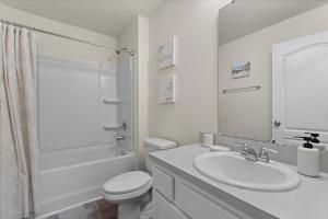 a white bathroom with a toilet and a sink at 6 Beds 12 Mins To The Beach Pets Ok Fenced Yd in Palm Coast +52 photos