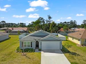 a house with a garage in a yard at 6 Beds 12 Mins To The Beach Pets Ok Fenced Yd in Palm Coast