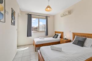 a bedroom with two beds and a window at Royal Seacrest amazing location 2 Bed Apartment by VICHY Holidays in Paphos