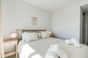 Un dormitorio con una cama blanca con almohadas blancas. en Casa Aranya, en Estepona 15 fotos más