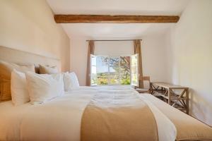 een slaapkamer met een groot wit bed met een raam bij Propriété d'exception - Piscine et Tennis in Venelles +52 foto's