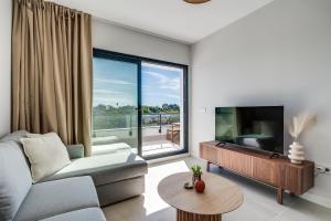 Una sala de estar con un sofá y un televisor de pantalla plana. en Casa Aranya, en Estepona