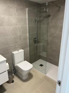 Un baño con inodoro y ducha de cristal. en Casa Aranya, en Estepona