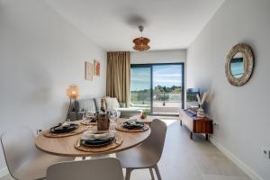 Un comedor y una sala de estar con mesa y sillas. en Casa Aranya, en Estepona
