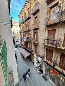een groep mensen die in een straat naast een gebouw lopen bij Azahar Homes - Murcia Centro in Murcia