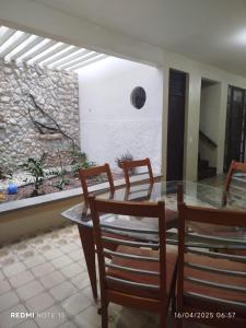 ein Esszimmer mit Glastisch und Stühlen in der Unterkunft Casa grande para o São João in Campina Grande