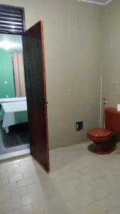 ein Badezimmer mit einer roten Toilette und einem Waschbecken in der Unterkunft Casa grande para o São João in Campina Grande