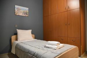 a small bedroom with a bed with wooden cabinets at Hara House in Vonitsa