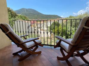 two rocking chairs on a balcony with a view at Villa Stella Marina in Teulada