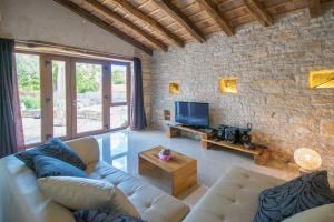 a living room with a couch and a tv at Villa Irena, a romantic villa nestled in the heart of Istria in Pulići