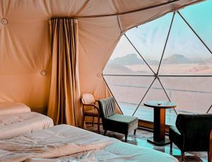 a room with two beds and a view of the desert at Shebara Camp Wadi Rum in Wadi Rum