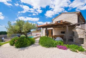 a stone house with a swimming pool and a building at Villa Irena, a romantic villa nestled in the heart of Istria in Pulići