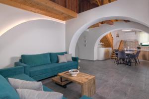 a living room with a blue couch and a table at ElaionHill-villa in Gennadi