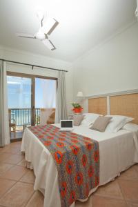 a bedroom with a bed with a laptop on it at Hostal la Savina in La Savina