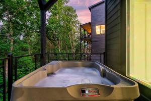 a bath tub sitting on a balcony with a house at Spring Splash Retreat - Pool Hot Tub & Games in Catlettsburg