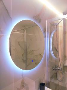 a bathroom with a round mirror on the wall at Piscis Of The Sea Benidorm in Benidorm