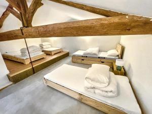 two beds in a room with wooden beams at L'Heure dorée, au coeur du Beaujolais in Lacenas