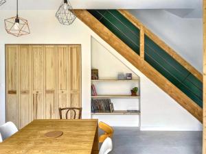 a dining room with a wooden table and chairs at L'Heure dorée, au coeur du Beaujolais in Lacenas