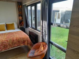 a bedroom with a bed and a window at Tiny House Egmond in Egmond aan den Hoef