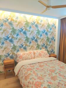 a bedroom with a large bed with a tropical wallpaper at Piscis Of The Sea Benidorm in Benidorm