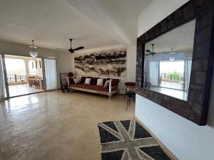 a living room with a couch and a large mirror at Casa Sanaa - Sea view in Watamu