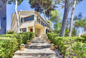 una casa con árboles y un camino de piedra en Villa Cala Estancia Mercedes, en Can Pastilla