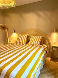 a bedroom with a bed with yellow and white stripes at Appartement terrasse centre Saint Martin in Saint-Martin-de-Ré