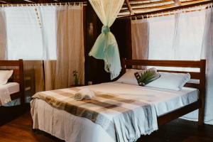 a bedroom with a bed with a towel on it at Villa Arapiuns - 6 Bangalôs na Floresta in Santarém +226 photos