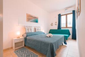 - une chambre avec un lit et une chaise verte dans l'établissement Giobo Mare, à La Caletta