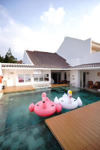 una piscina con dos botes inflables en el agua en Kala Cabin Cinema, en Bongkor 1