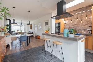 a kitchen with a counter with stools and a counter top at Wijkiki Surf House in Wijk aan Zee