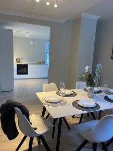 ein Esszimmer mit einem weißen Tisch und Stühlen in der Unterkunft Skuteviken House in Bergen