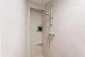 a bathroom with a shower with white tiles at 2 Bedroom Apartment City Center in Belfast