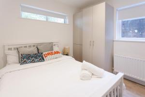 a white bedroom with a large white bed and a window at 2 Bedroom Apartment City Center in Belfast