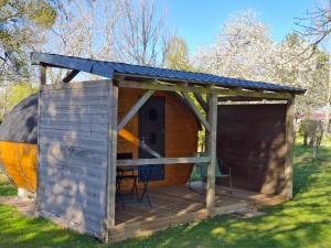 a wooden shed with a table and chairs in a field at Le Cabanon du camping 2 in Bannes +5 photos
