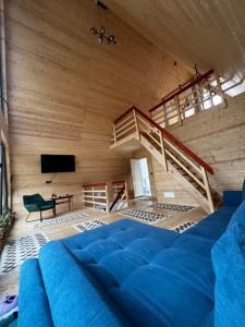 a living room with a blue couch and a staircase at Chalet Green in Cazaci
