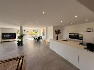 a kitchen with white cabinets and a dining room at Luxee Apartment in Friedrichshafen