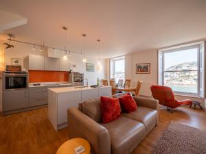 a living room with a couch and a kitchen at Riverside Apartment with Stunning Views & Patio in Dartmouth