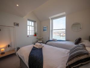 a bedroom with two beds and a window at Riverside Apartment with Stunning Views & Patio in Dartmouth