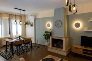 a living room with a table and a fireplace at THETIS Luxury House in Nikiti