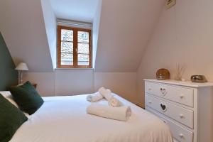 a bedroom with a white bed with towels on it at Appartement Beraweka avec Climatisation et Salle de Sport in Colmar