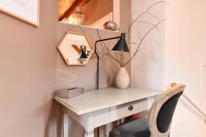 a white desk with a chair and a lamp at Appartement Beraweka avec Climatisation et Salle de Sport in Colmar +30 photos