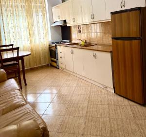 a kitchen with a refrigerator and a table and a couch at Central- AZURE -Stay in Përmet