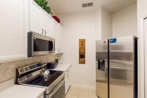 eine Küche mit einem Kühlschrank aus Edelstahl und einer Mikrowelle in der Unterkunft BAHAMA BAY RESORT in Kissimmee
