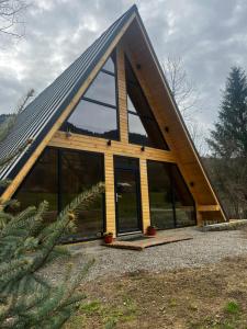 CazaciChalet Green的一个带大窗户的三角形屋顶的房子